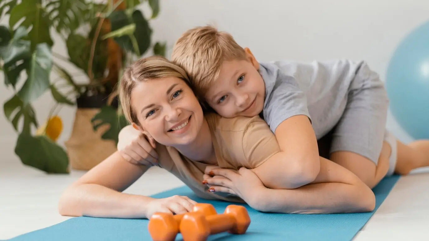 Halbtotale einer Frau und eines Kindes auf einer Yogamatte.